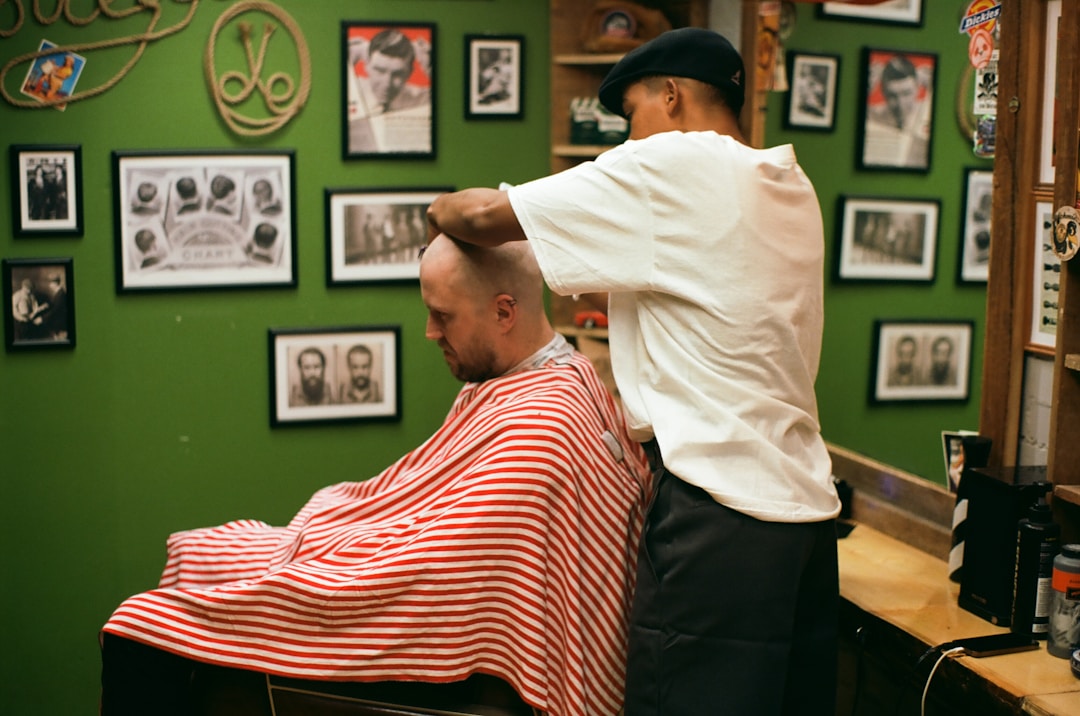 Professional barber cutting low fade for thinning hair