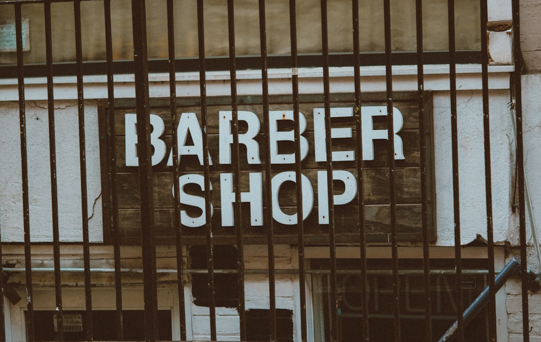 Professional barber consultation discussing low fade haircut pricing and service options at Queens NYC barbershop