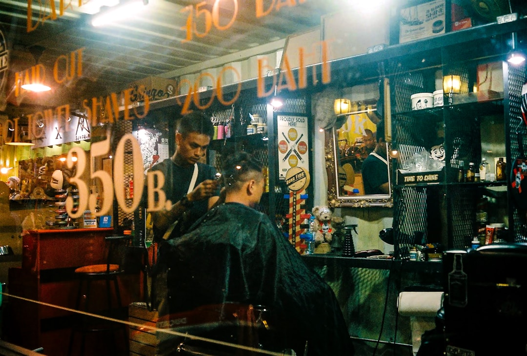 Professional low fade haircut process showcasing expert barber consultation and precision cutting techniques at neighborhood barbershop in Queens NYC