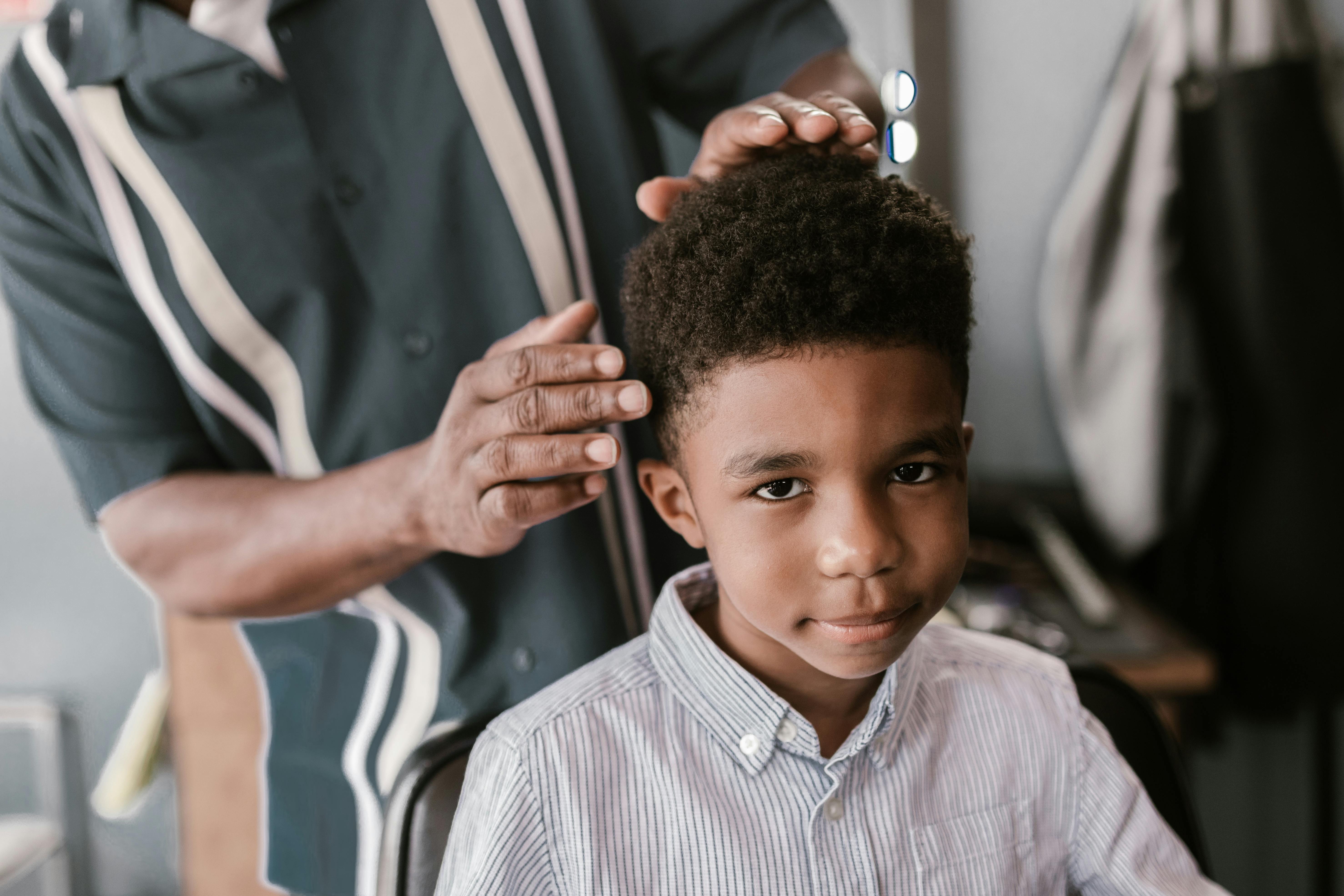 Children's haircut service at DIDA barbershop Queens NYC - professional barber cutting young boy's hair with gentle care